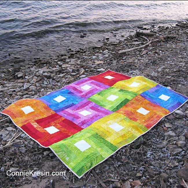 Rainbow Rail Fence baby quilt tutoral down by river on the rocks