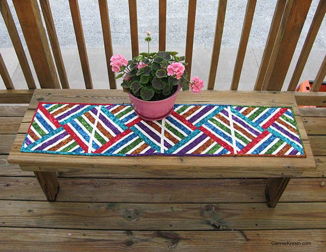 Bright Jewel strip pieced table runner on deck