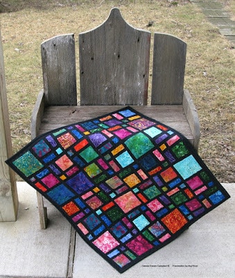 Mini Scattered quilt in batiks on bench