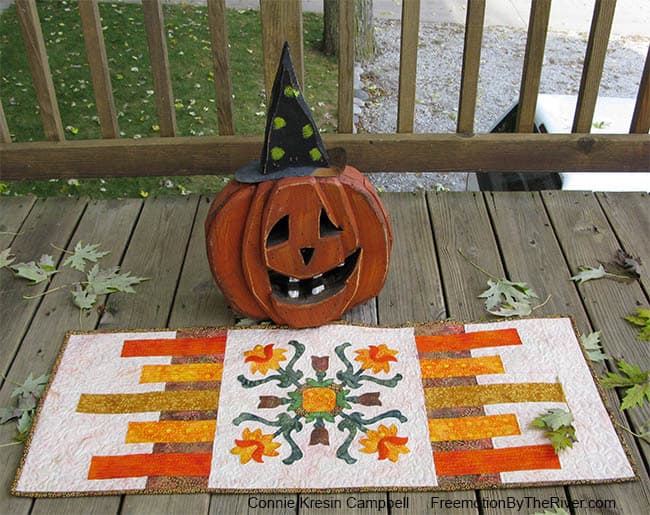 Folk Art Quilted Tradtions applique table runner with a Halloween pumpkin