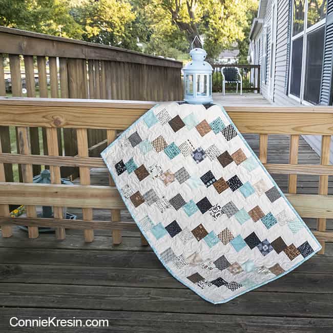 Mini Falling Charms quilted tablerunner on deck rail