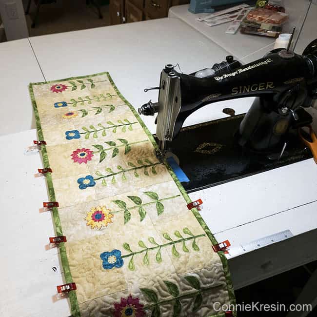 Wild Flowers Row getting the binding sewn on by machine using clips