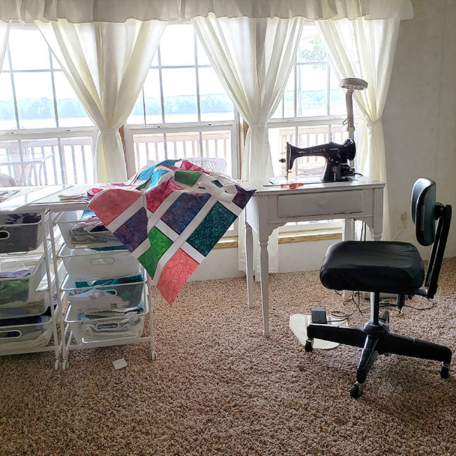 Stack batik quilt with vintage sewing machine in living room