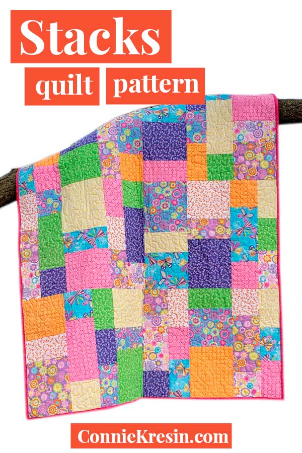 Stacks quilt pattern made with rainbow quilt fabrics for children