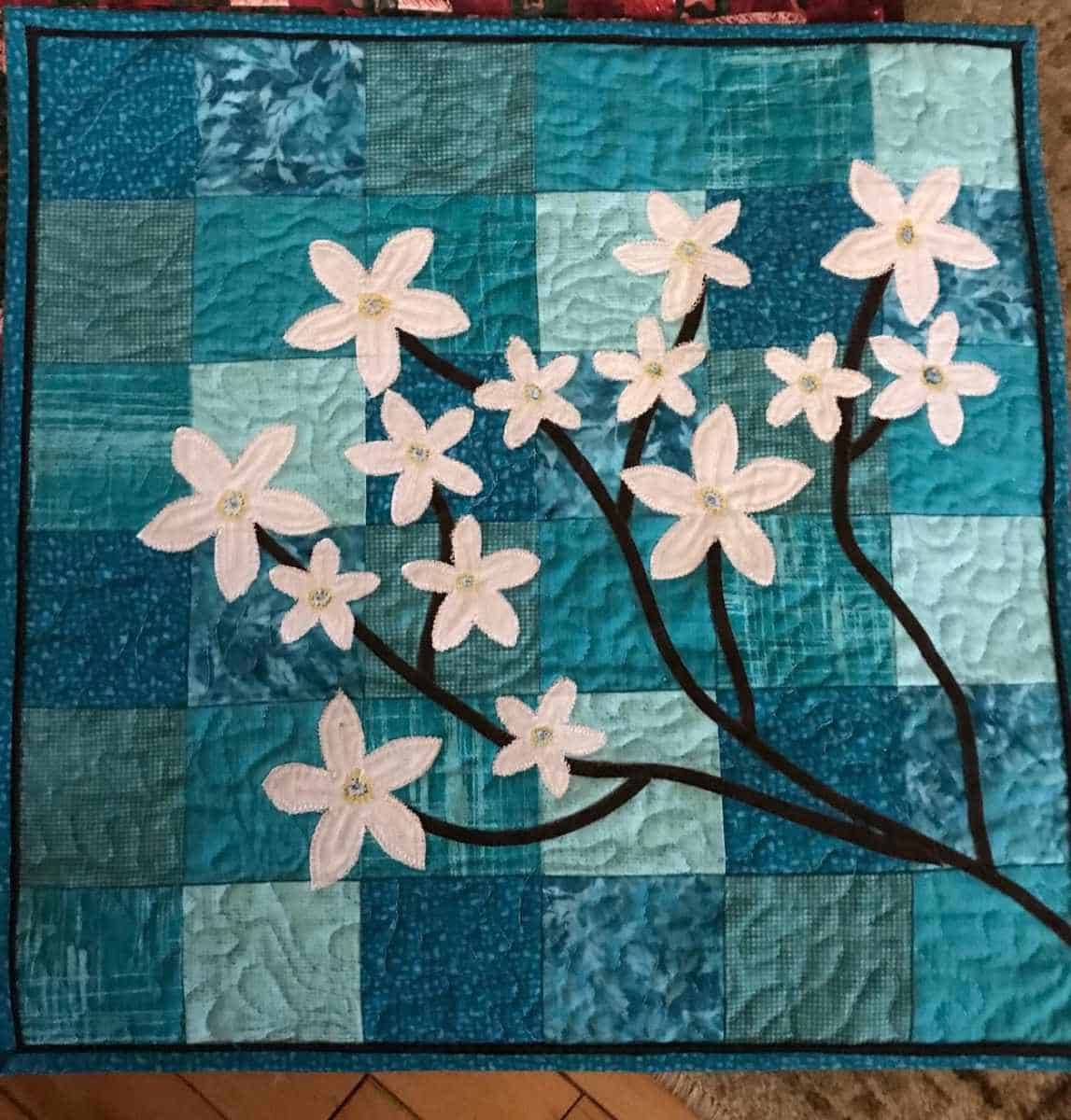 Forget Me Not wall hanging in teal quilt fabrics