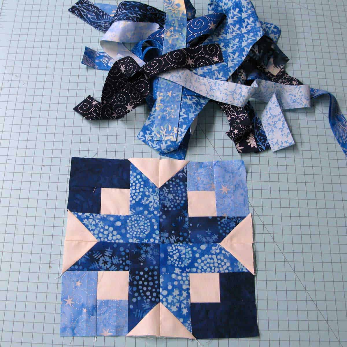 Narrow strips of batik Christmas fabrics and one Box Quilt block