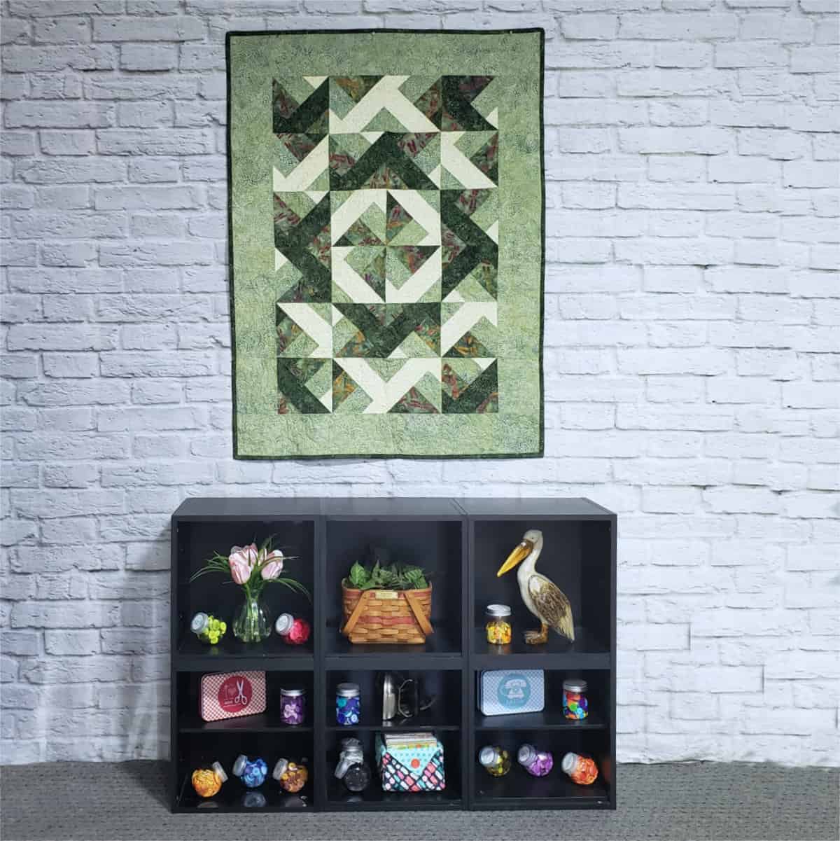 Green batik diagonal quilt on wall with display
