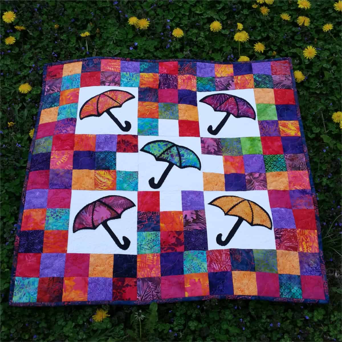 The quilt laying in the grass