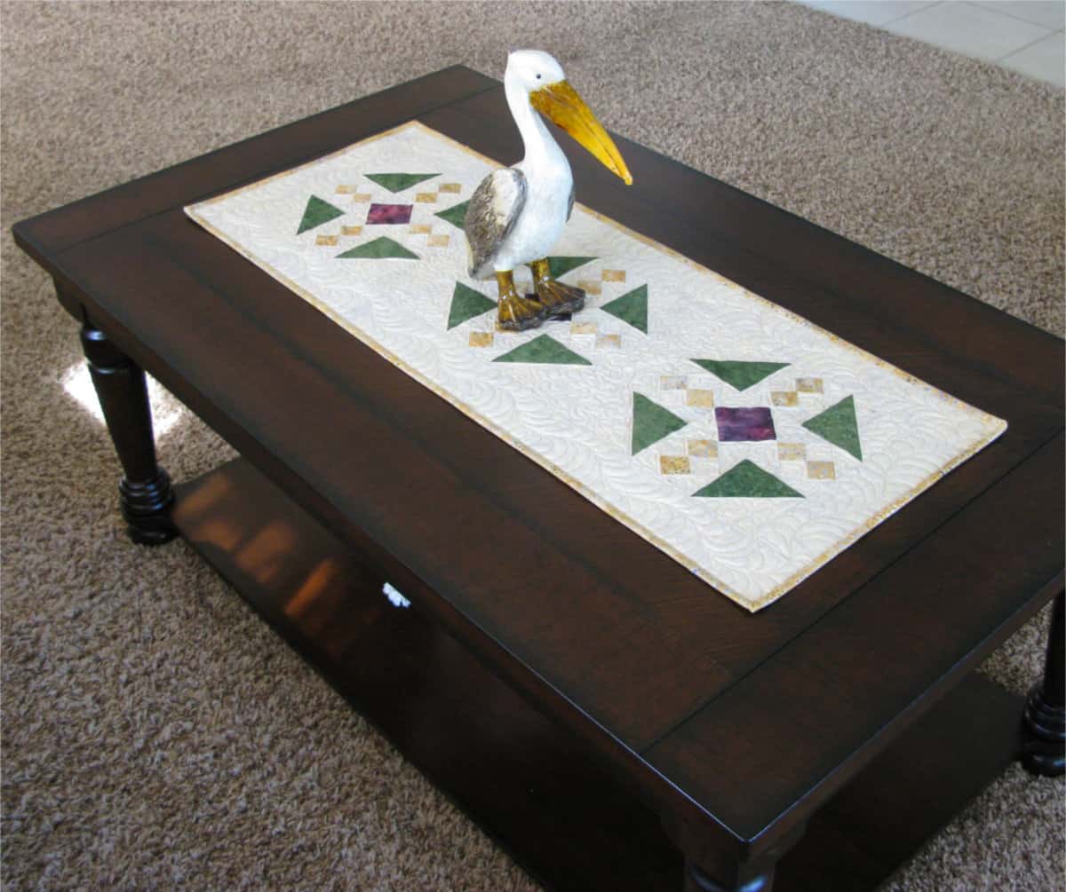 Table runner with a pelican statue on it
